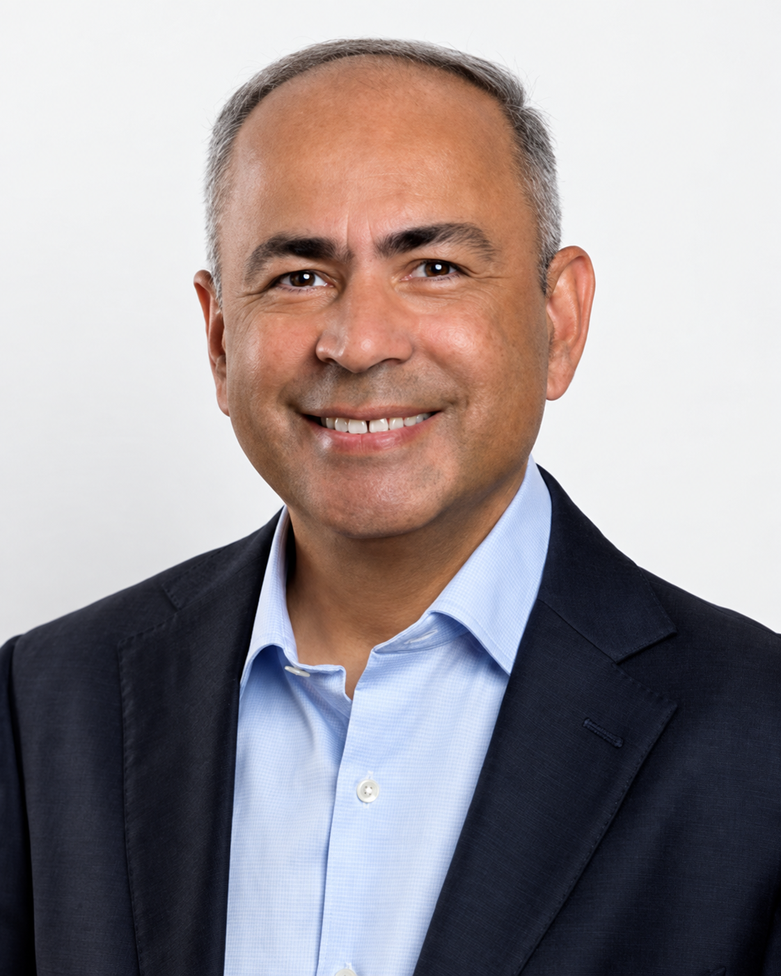 Rajeev Dewan, smiling in a navy jacket and blue shirt